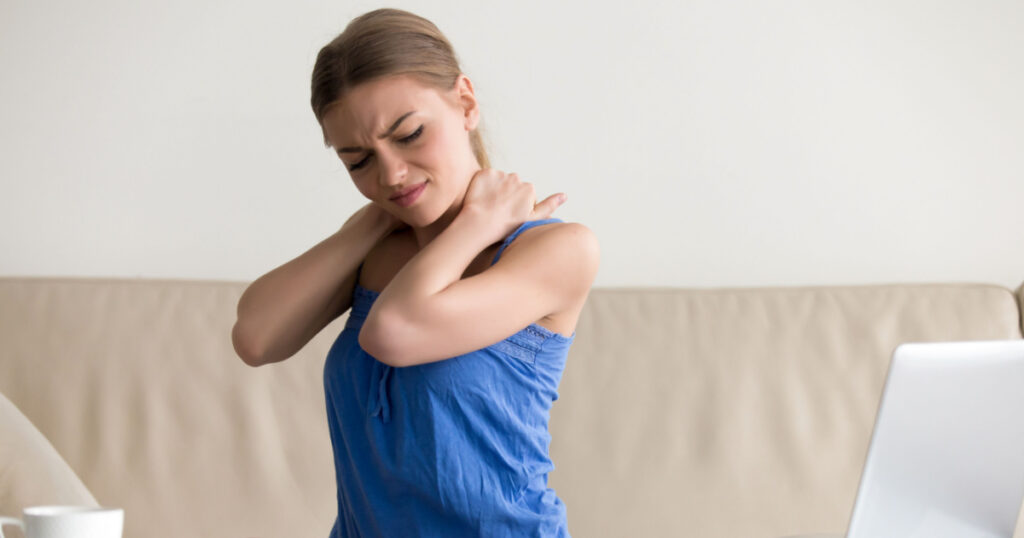 Tired woman feeling neck pain, massaging tense muscles, suffering from chronic shoulder back ache after long work on laptop computer at home, sedentary work, incorrect posture problems, fibromyalgia