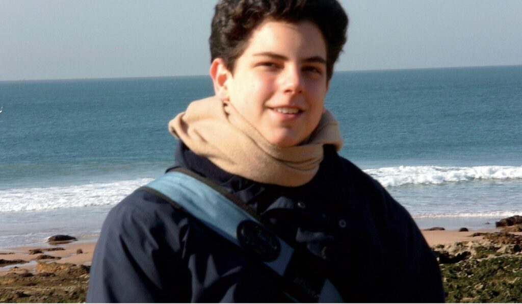 Carlo standing at the beach.
