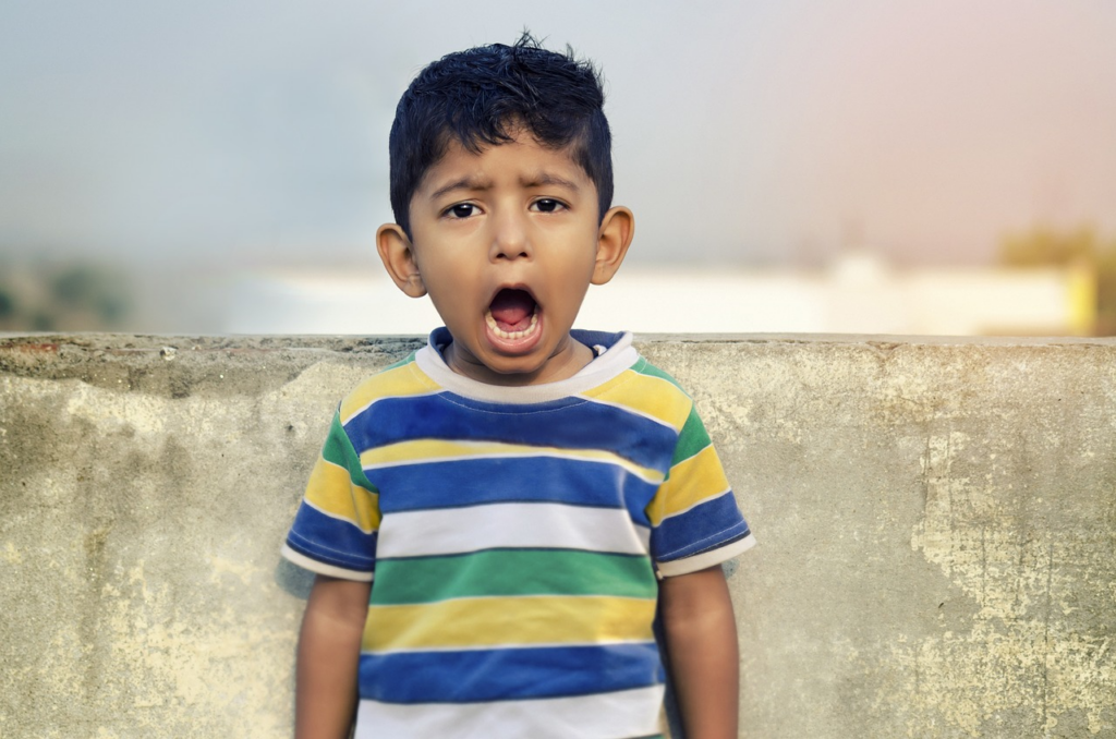 child with mouth open lookign forward