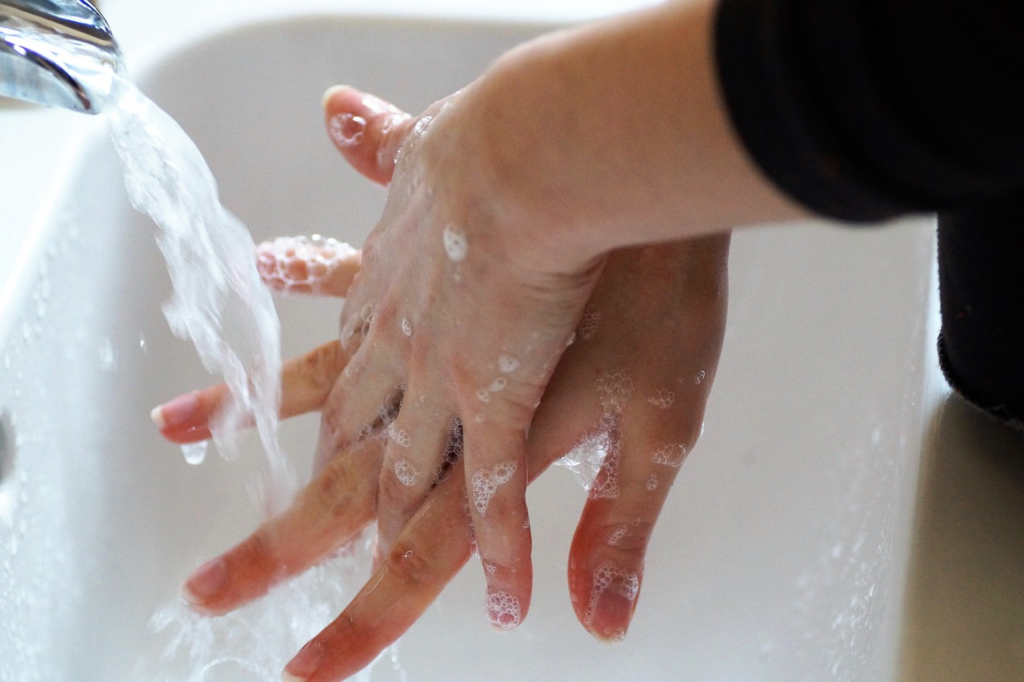 washing hands with soap in a sink