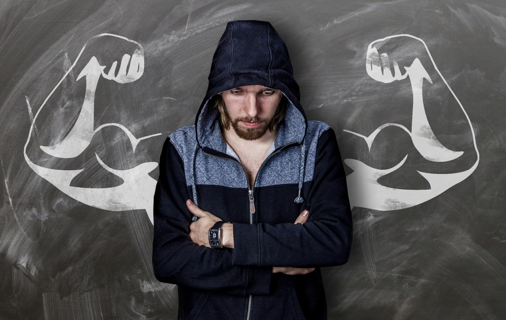 a man crossing his arms in front of. a large-armed picture
