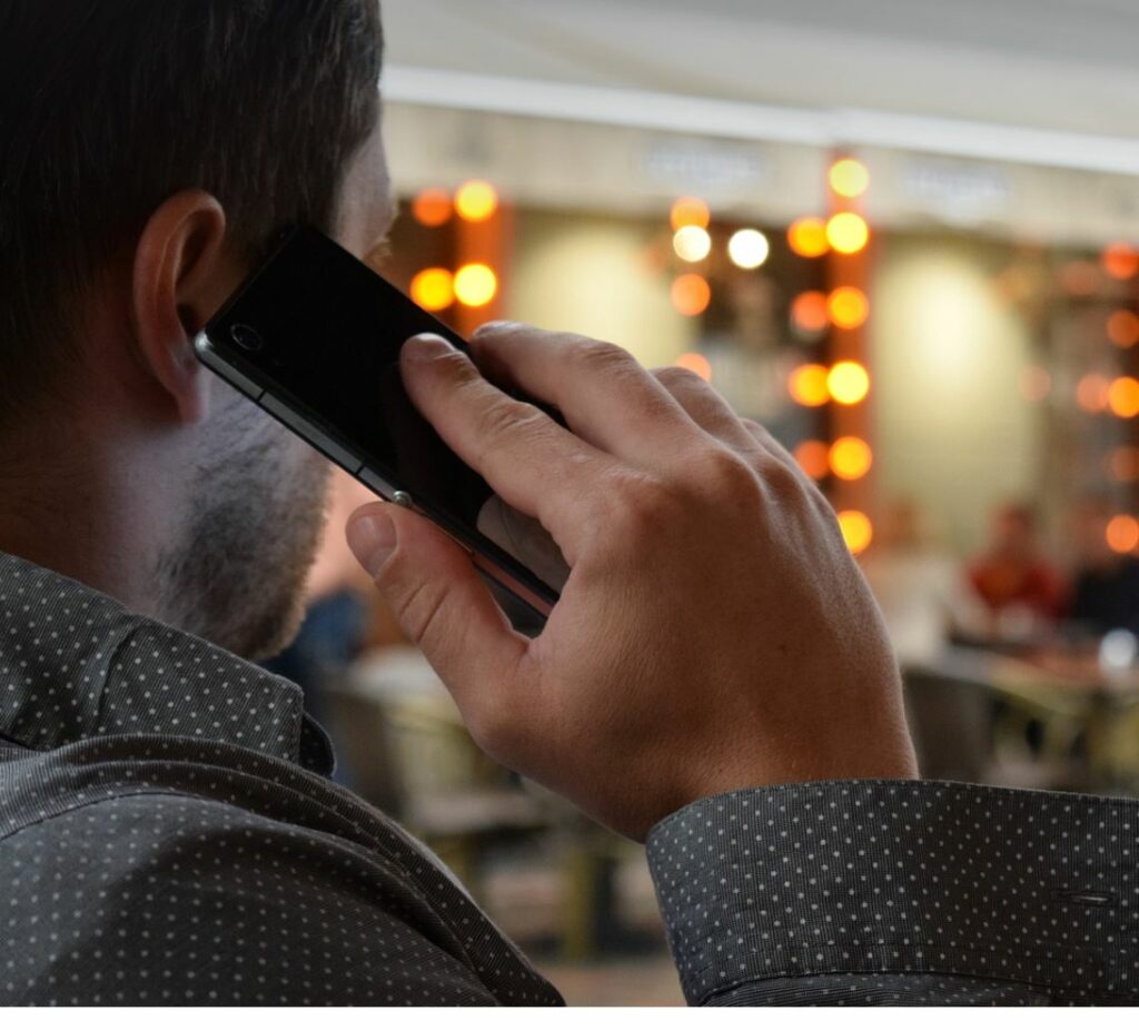 Man talking on the phone. Blurred lights in the background.