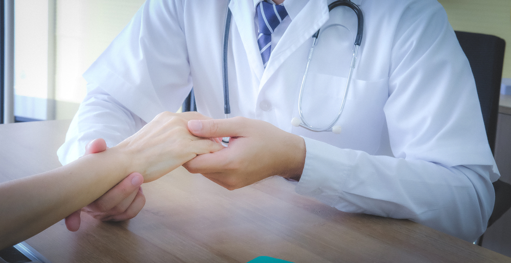 doctor touching hand patient to check wrist bone after broken in hospital. 