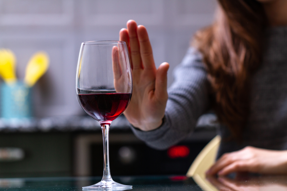 Woman refuses to drink a alcohol. Female alcoholism concept. Treatment of alcohol addiction. Quit booze and alcoholism.