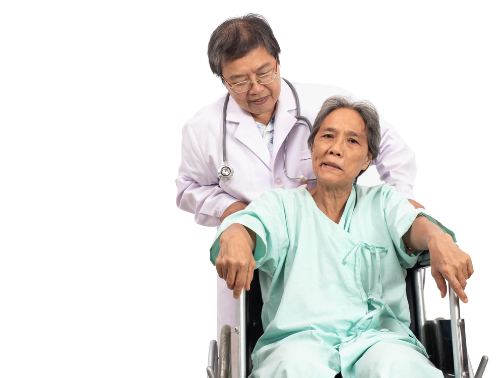 Asian elderly woman with a paralysis, stroke or cerebrovascular accident (CVA) symtoms sitting on wheelchair and the doctor take care. Elderly health care.