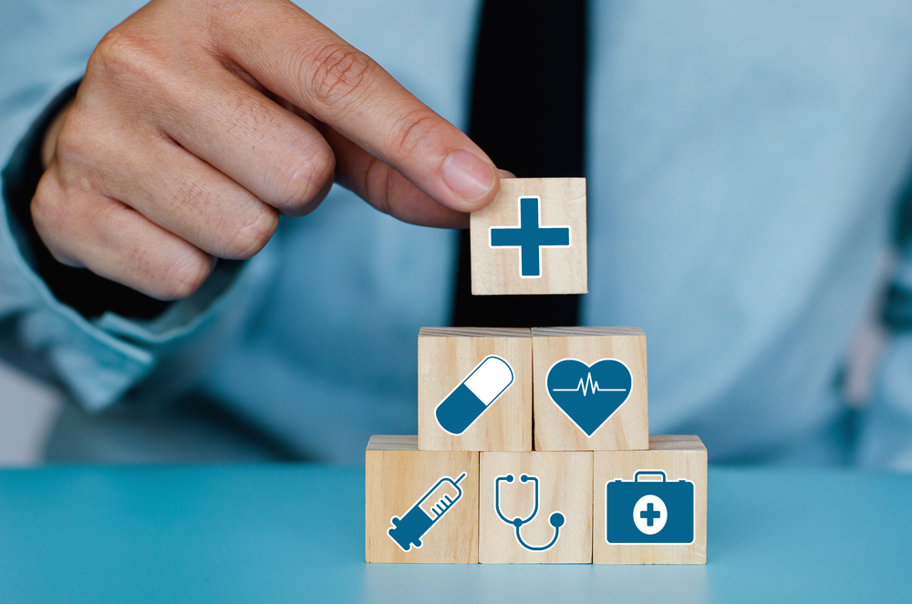Good Healthcare and Insurance concept.Business hand choose plus sign on wood cube block,Positive quantity,Take care and Safety.