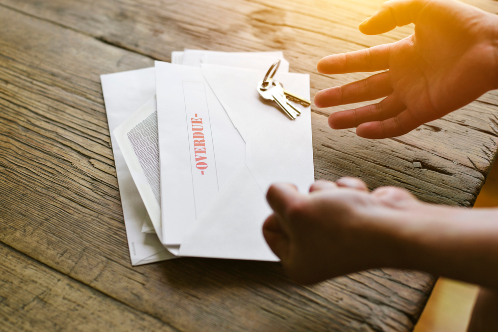 Expressive hands react to an overdue letter in an envelope - Financial hardship - Crisis