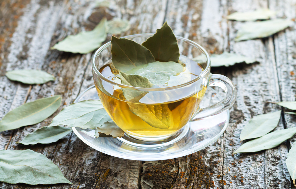 Natural bay leaf herbal tea in glass cup on rustic wooden table