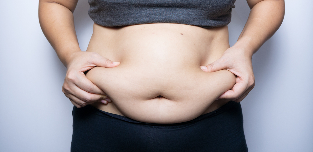 Fat woman hand holding fat belly on white background.