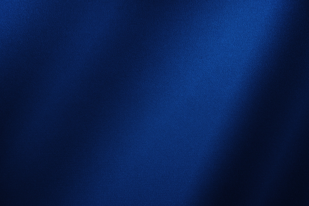Abstract dark background. Silk satin fabric. Navy blue color. Elegant background with space for design. Soft wavy folds. Christmas, birthday, anniversary, award. Template.