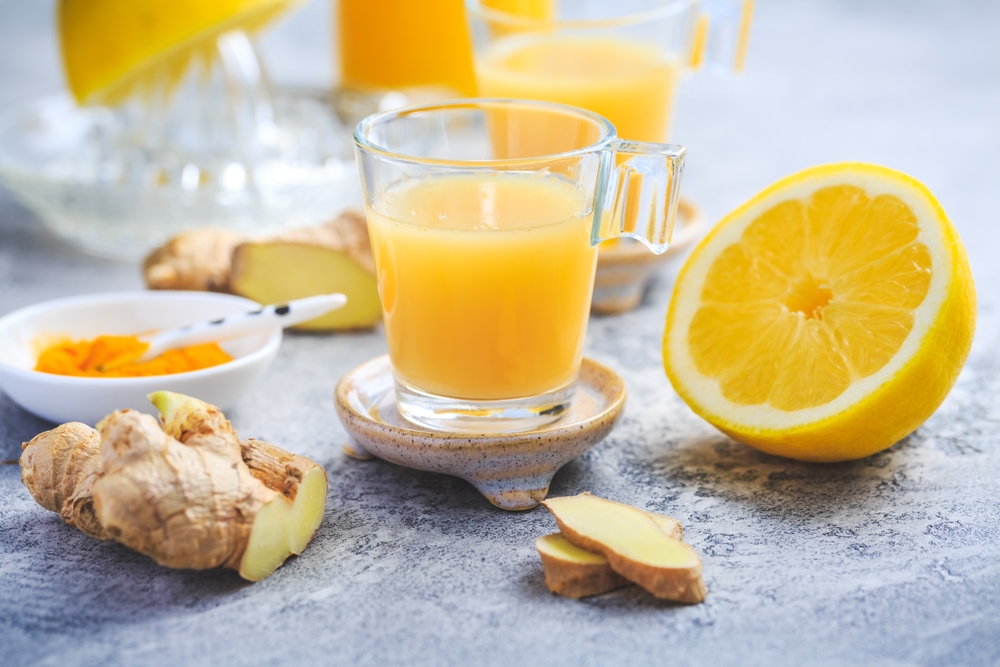 Homemade turmeric lemon ginger shots in small glasses, healthy Ginger Lemon Turmeric Shot ? ideal to boost the immune system during the winter