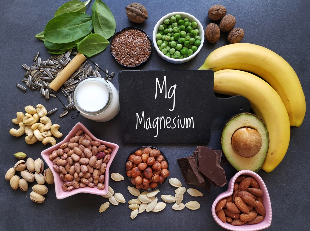 Magnesium rich foods. Natural food sources of magnesium. Assortment of fresh fruit, vegetable, nuts and seeds high in magnesium. Banana, nuts, seeds, beans, avocado, milk, dark chocolate, spinach...