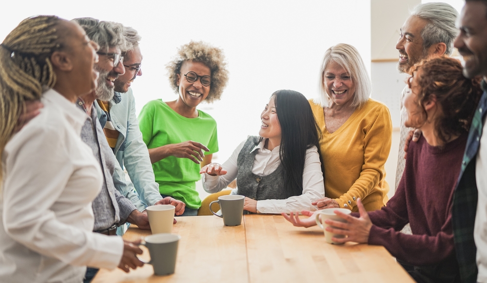 Multigenerational people having fun together inside kitchen while drinking coffee