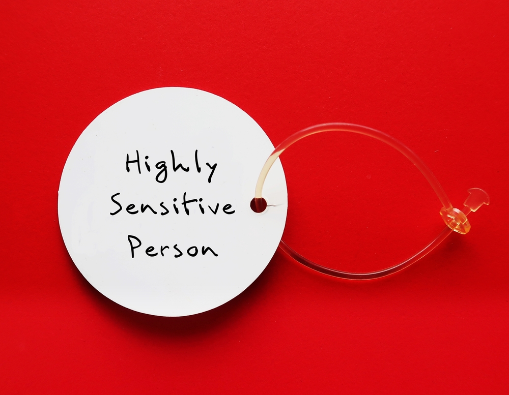 Tag on red background with handwritten text HIGHLY SENSITIVE PERSON, refers to people who think and feel everything more deeply, more sensitive to the environment and social interactions