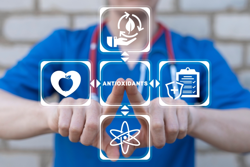 Doctor using virtual touch screen presses text: ANTIOXIDANTS. Natural Antioxidant Nutrition Healthy Eating Diet Medical Concept. Healthy foods rich in antioxidants.