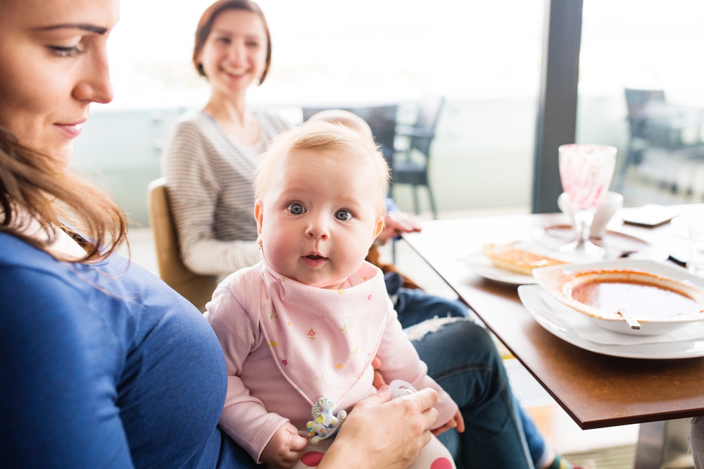 New mom friends going to restaurant with babies. Spending free time during maternity leave together in city.