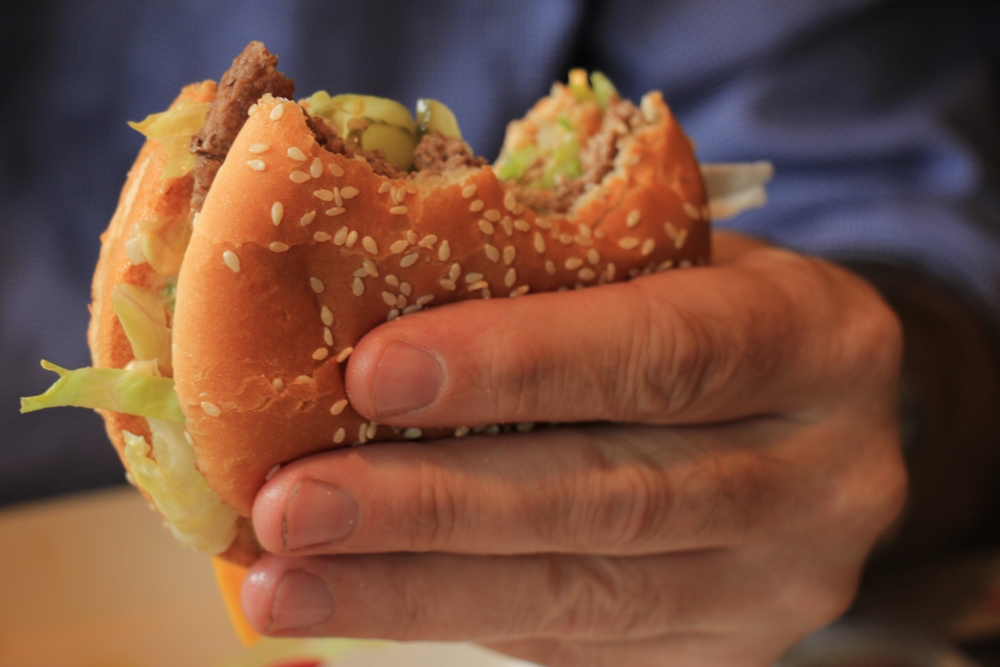 Man holding a fresh made hamburger