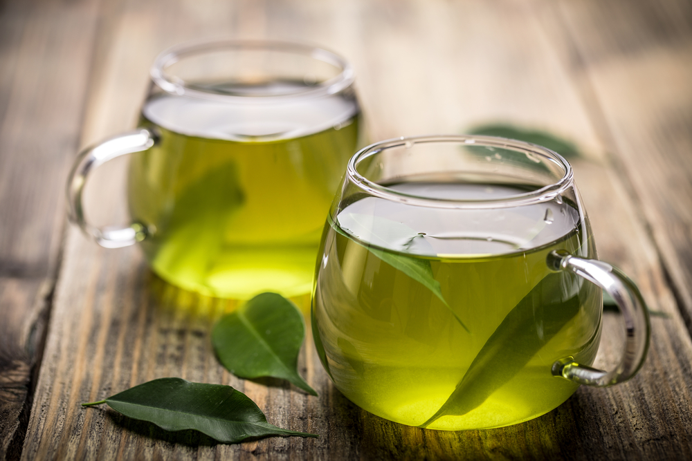 Fresh green tea with tea leaves in the water