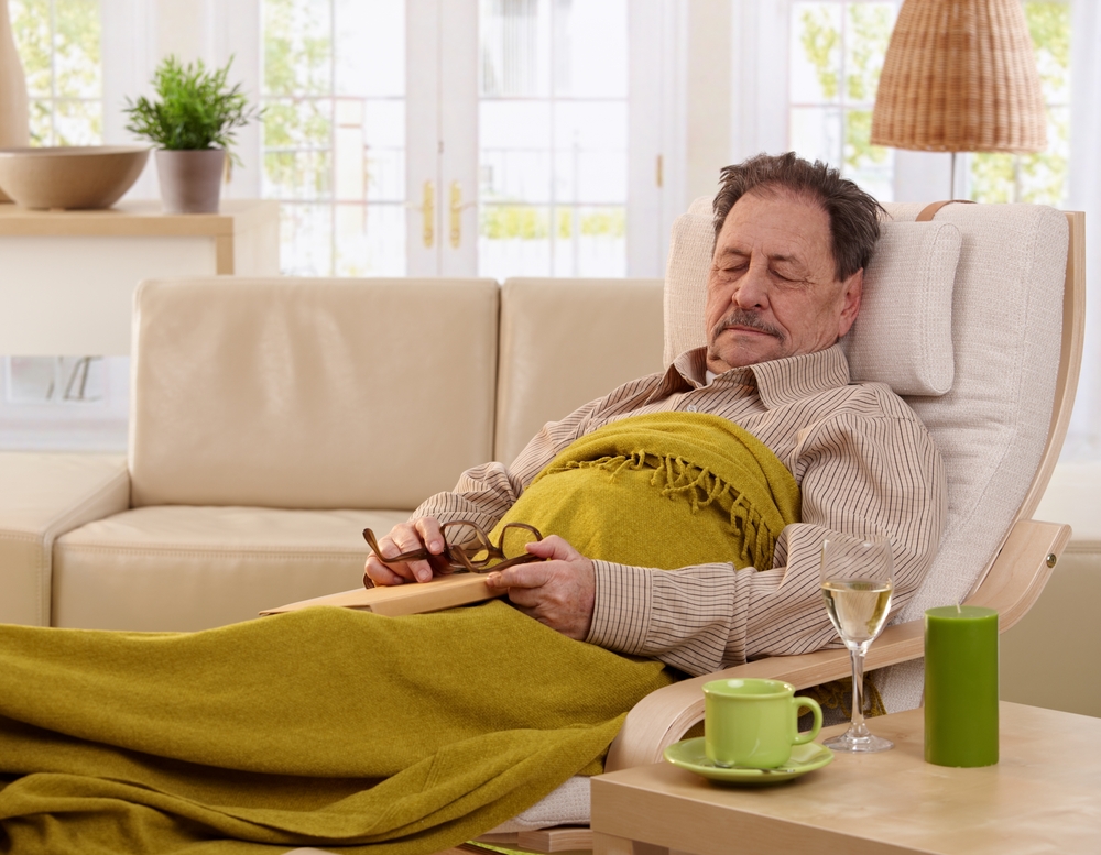 Senior man napping in armchair at home.?