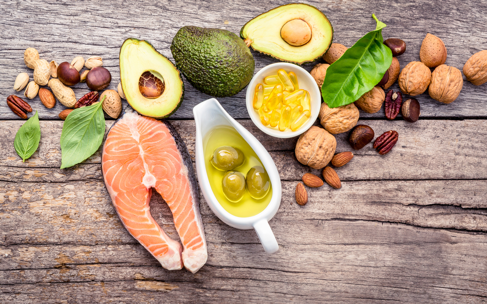 Selection food sources of omega 3 and unsaturated fats. Superfood high vitamin e and dietary fiber for healthy food. Almond,pecan,hazelnuts,walnuts,olive oil,fish oil and salmon on wooden background.