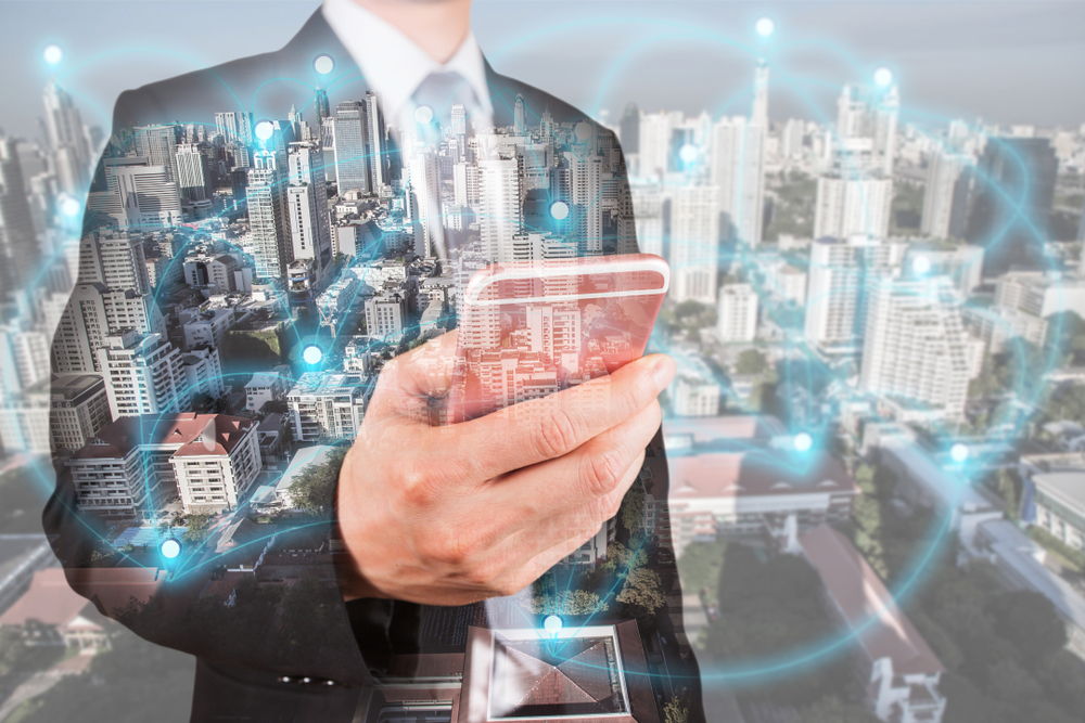 Double exposure of businessman use smartphone, communication 4G 5G node networking telephone cellsite andcityscape urban at foggy morning as business, technology and telecom concept