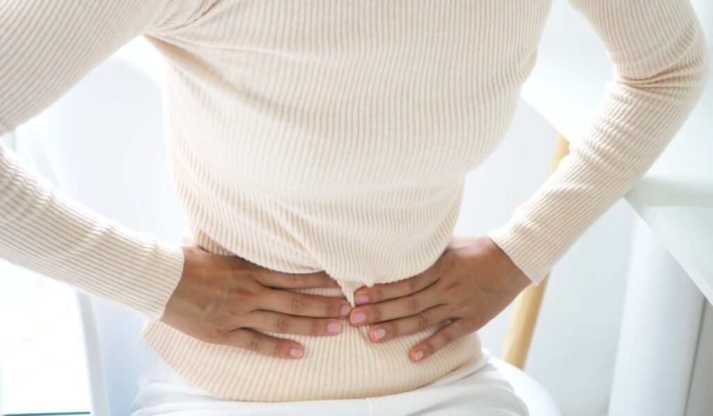 Woman with stomach pain causes of abdominal pain include inflammatory bowel disease-IBD. stomach ulcer irritable bowel syndrome (IBS), ulcerative colitis and microvilli. closeup photo, blurred.