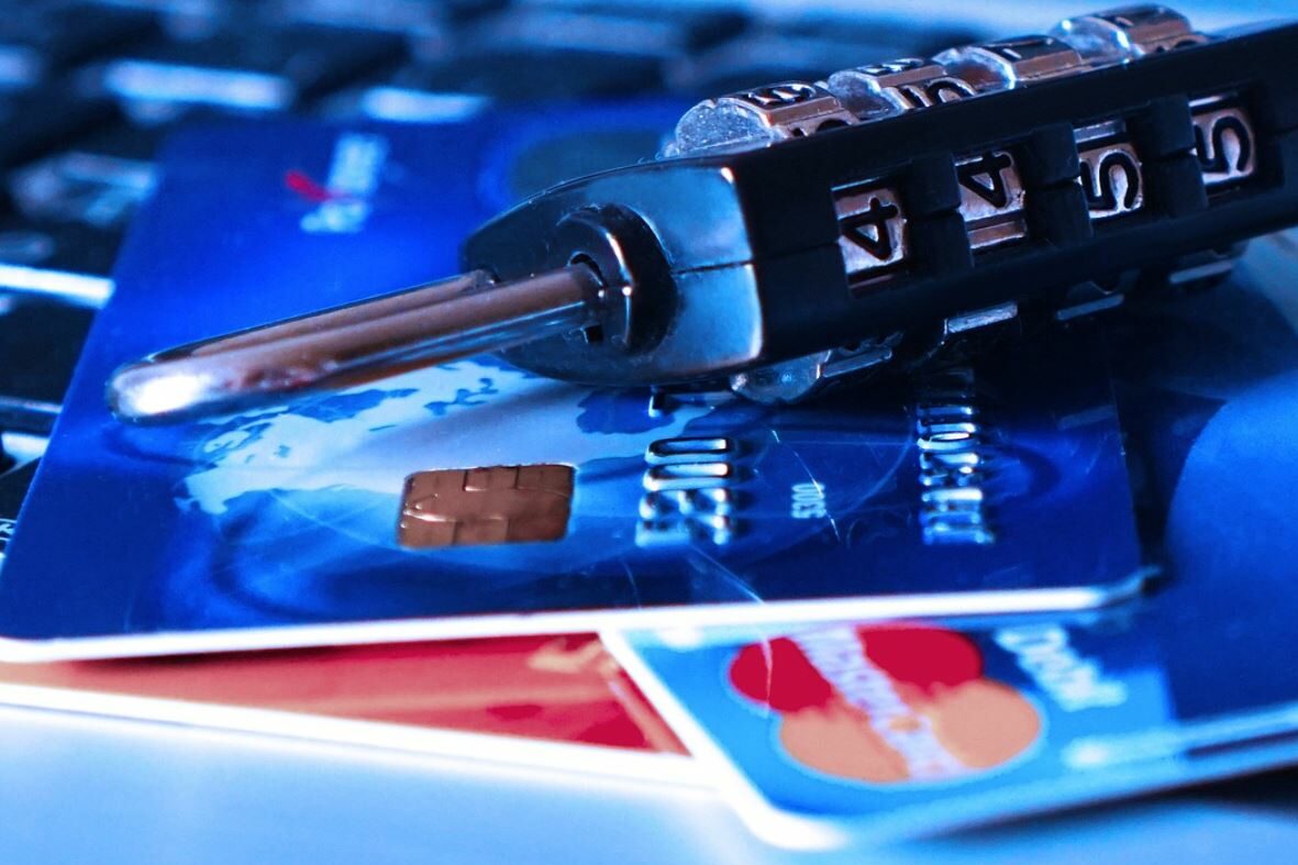 Credit cards and a lock. Blurred keyboard in the background. 