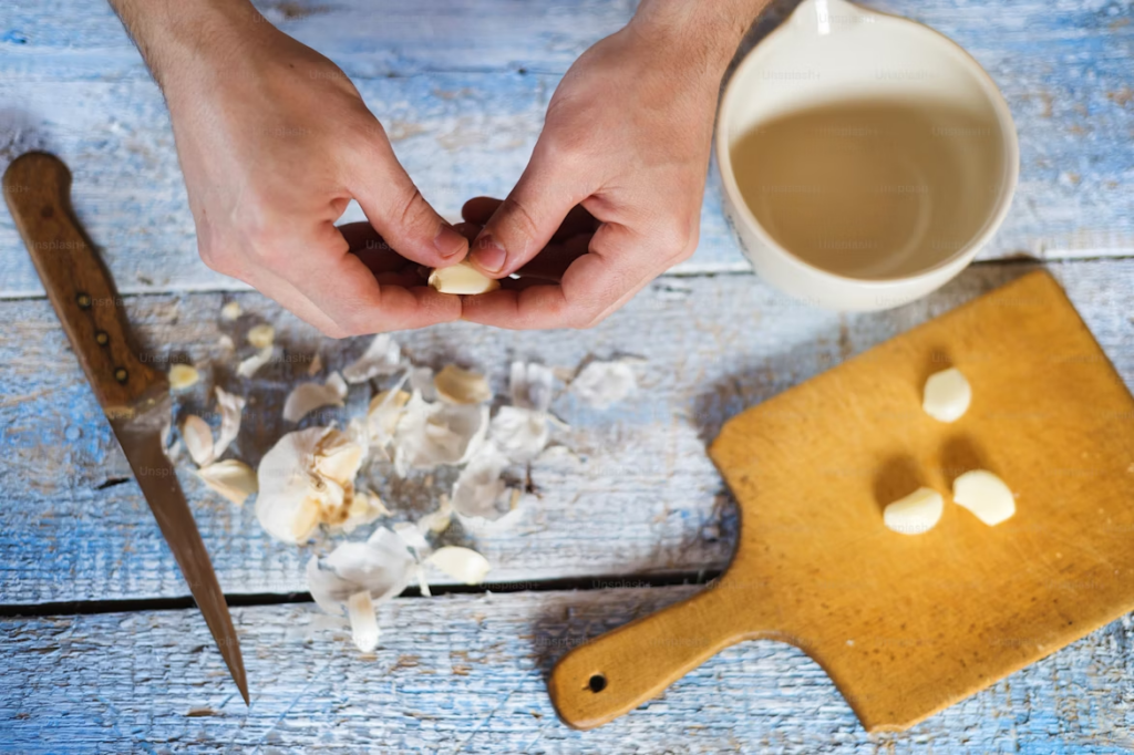 Man in the kitchen peeling garlic cloves