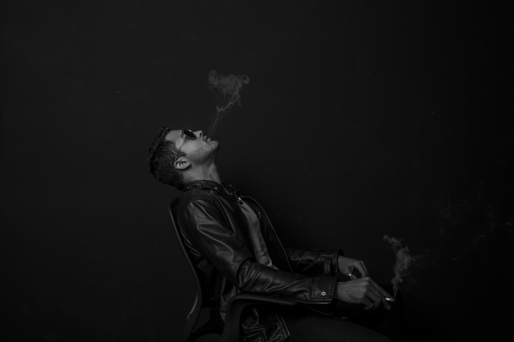 man smoking in black and white