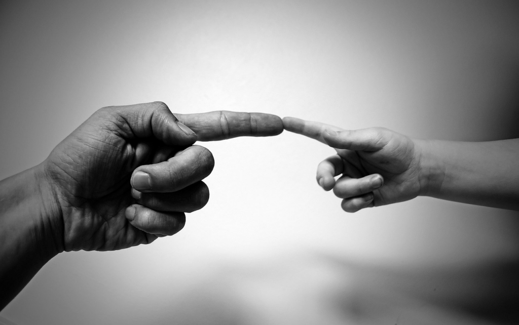 older and younger hand touching fingers