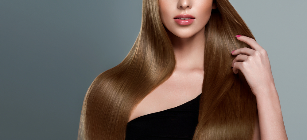 Beautiful model girl with shiny brown and straight long hair. Keratin straightening. Treatment, care and spa procedures. Smooth hairstyle