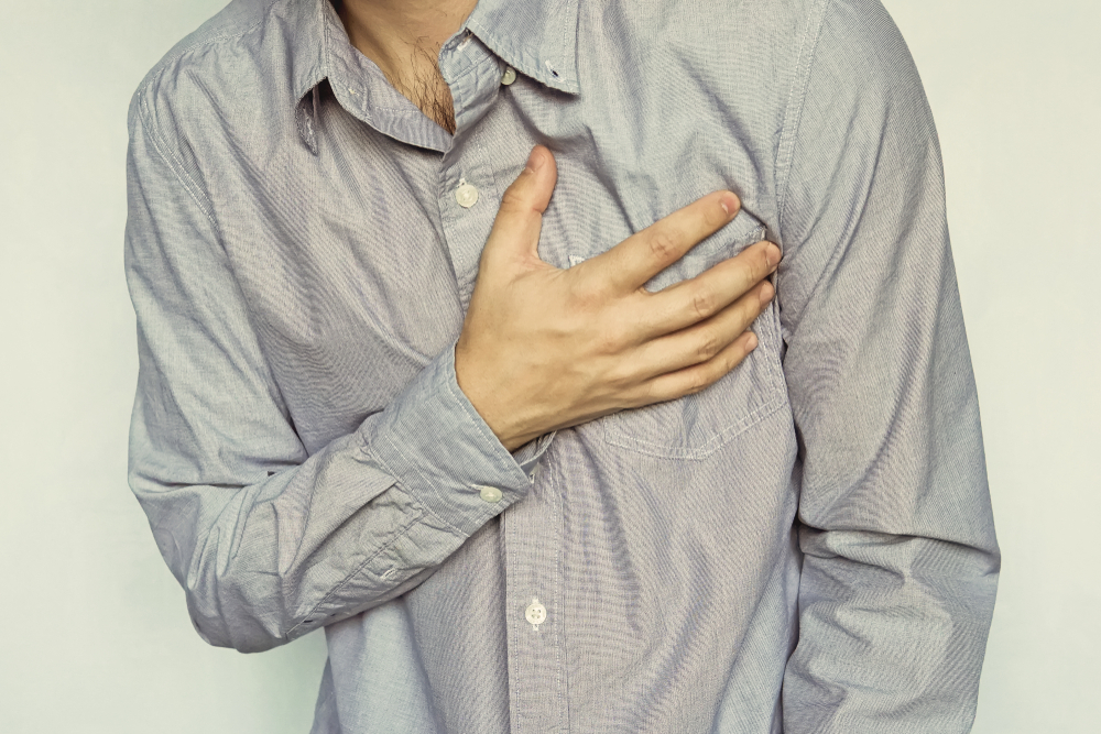 Man With Heart Attack. young businessman with the chest pain. guy in the blue shirt clings to his chest. patient with pain in the heart.