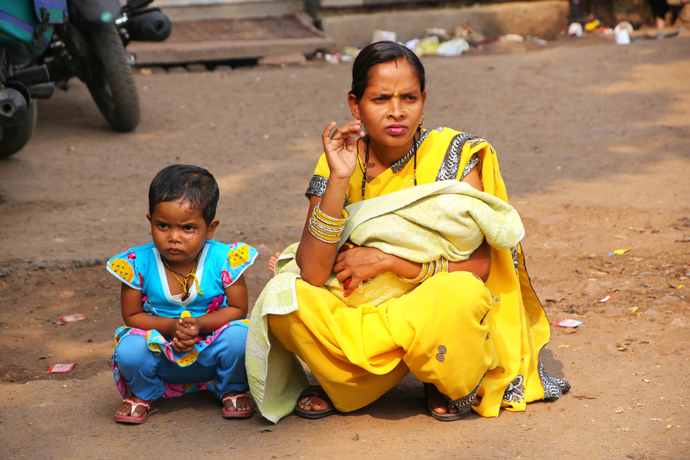 FATEHPUR SIKRI, INDIA-NOVEMBER 9: Unidentified woman with a girl sits at the street market on November 9, 2014 in Fatehpur Sikri, India. The city was founded in 1569 by the Mughal Emperor Akbar