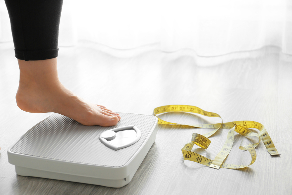 Woman with scales at home. Weight loss concept
