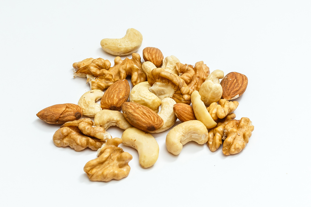 Various nuts isolated on white. nut, walnut, almonds, hazelnuts, pistachios, cashews, peanuts, pine nuts. Top view or flat-lay. Copy space