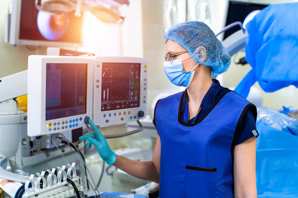Nurse near the screen of mechanical ventilation equipment. Hospital, surgical operating room. Life saving. Ventilation of the lungs with oxygen. Pneumonia diagnosting. COVID-19