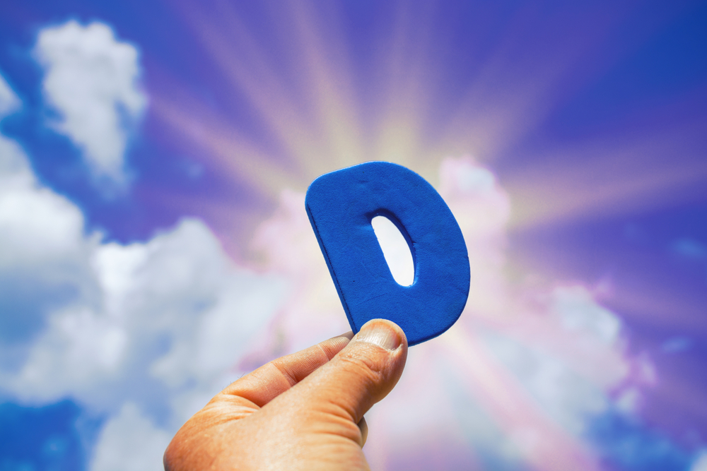 Letter D on the background of the sun. Vitamin concept