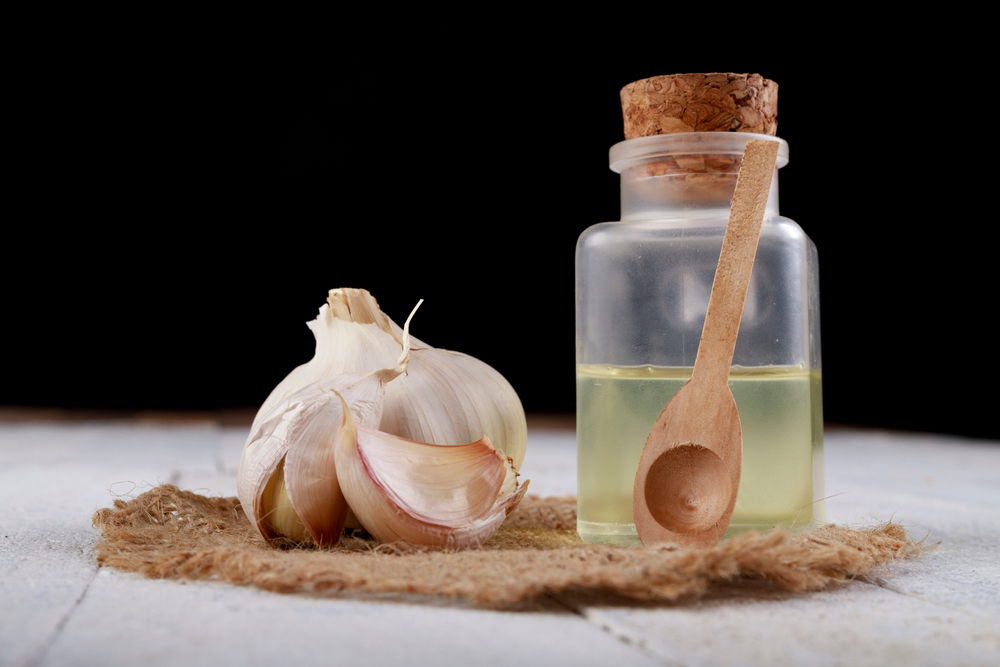Fresh garlic and squeezed flu juice. Home remedies to cure infections and colds. Light background.