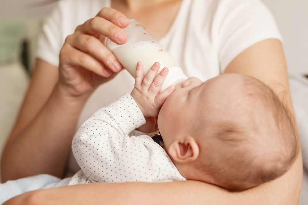 baby eats milk from a bottle