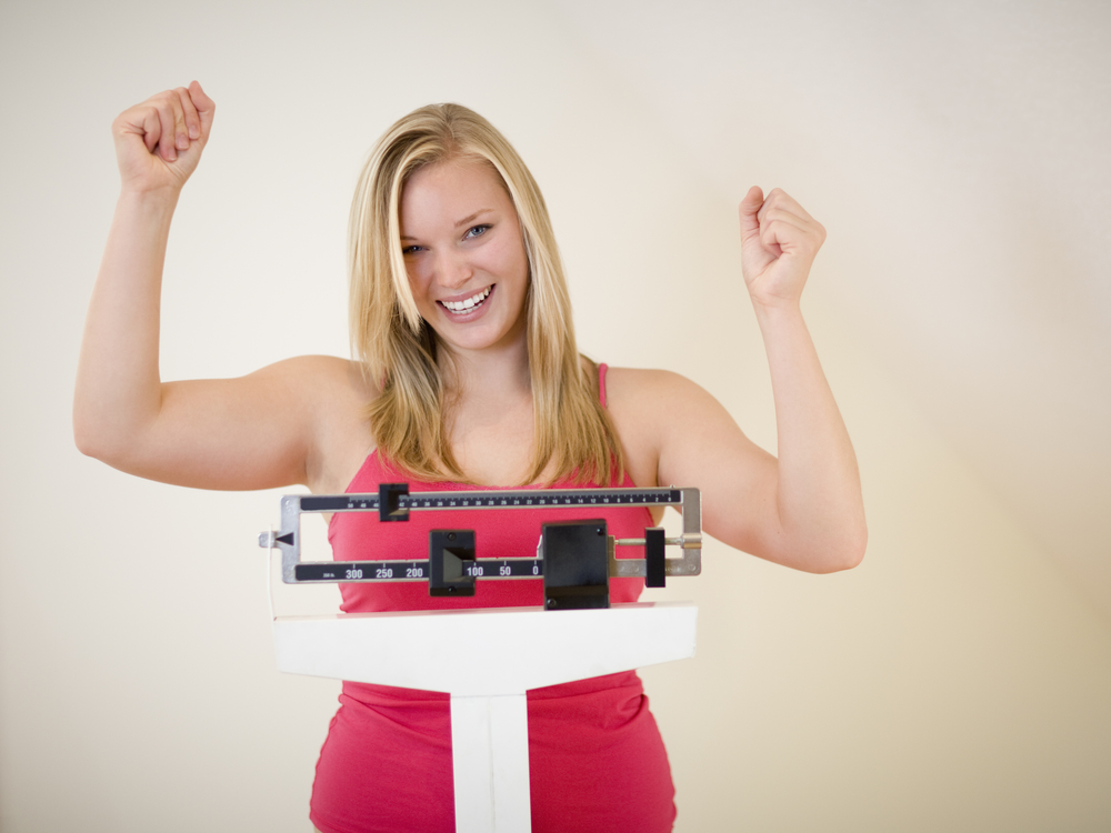 Cheering woman standing on scale