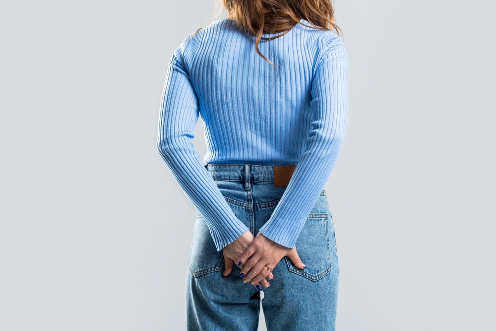 Hemorrhoids. Anus. Pain. Woman hand holding her bottom because having Abdominal pain and Hemorrhoids. Woman suffering from hemorrhoids, anal pain. A woman holds his hands to the ass feeling pain.