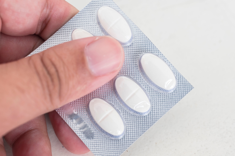 Holding a blister pack of Ciprofloxacin tablets. 500 mg antibacterial treatment. Medicine for sale at a drugstore or pharmacy.