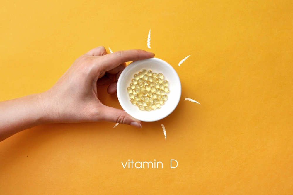 Tablets on a plate inside a picture of the sun and the inscription: vitamin D