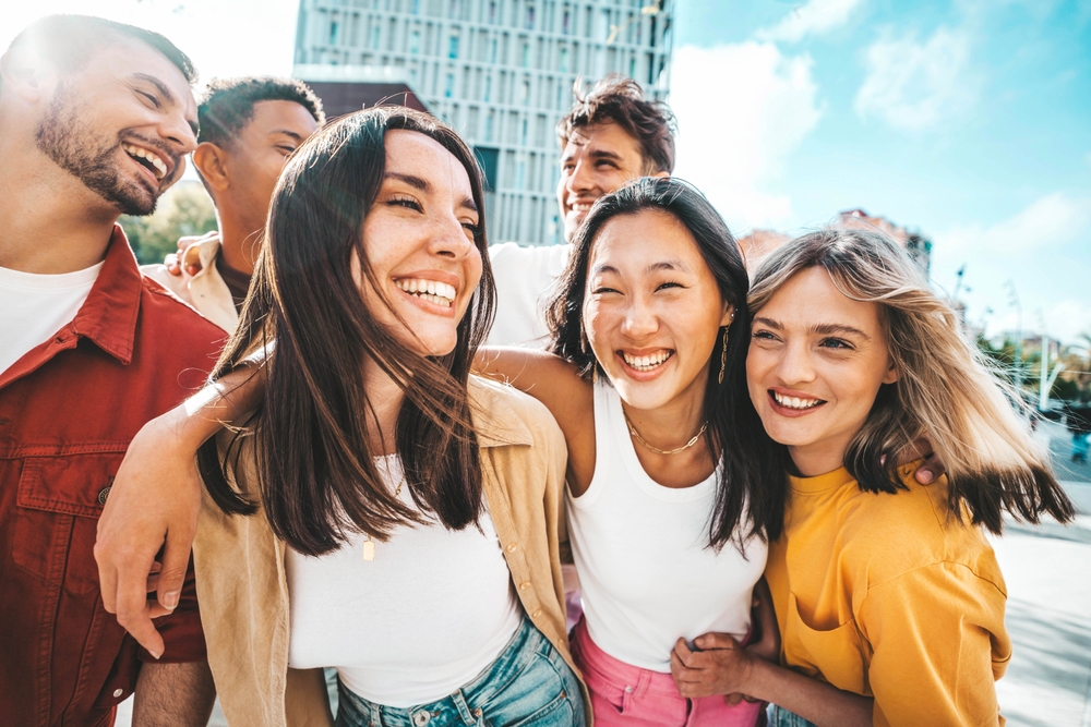 Multiethnic friends having fun walking on city street - Group of young people enjoying summer vacation together - Friendship concept with guys and girls hanging outside on a sunny day