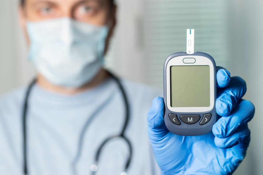 Doctor shows glucometer with glucose level. Doctor and patient diabetes consultation in office or clinic