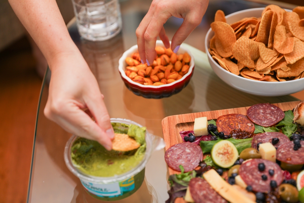 Hands and utensils gather around, embracing the communal spirit of a potluck dinner. Symbolizing unity, sharing, and indulgence as they enjoy a variety of desserts