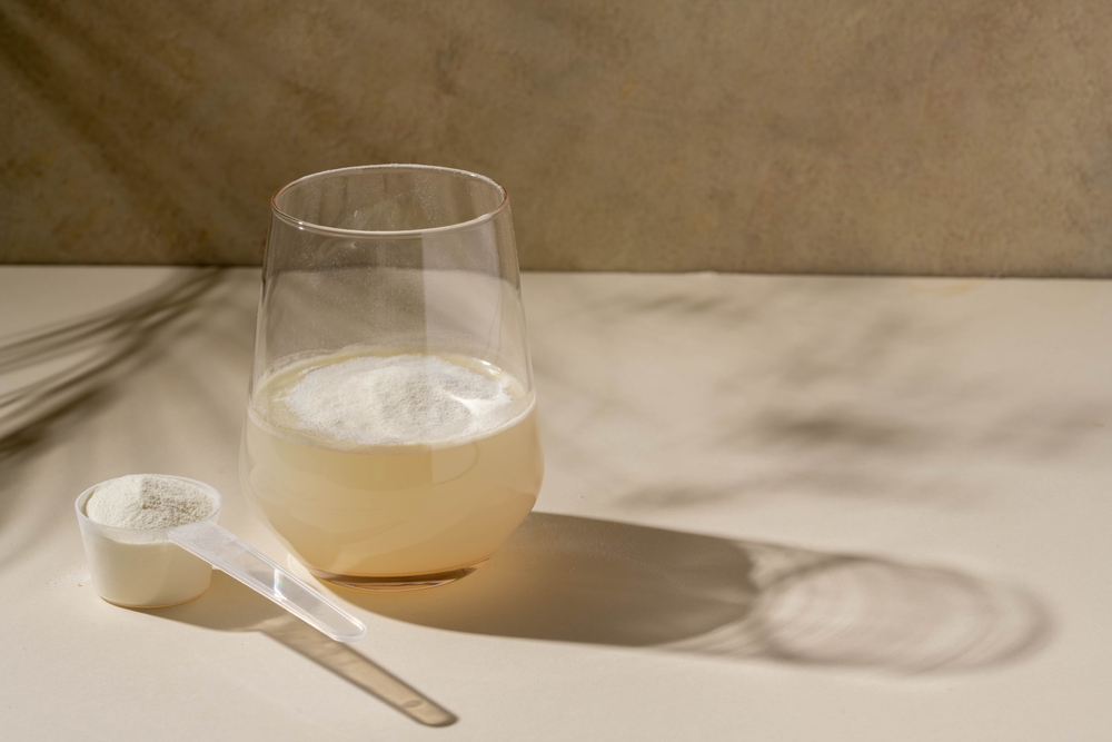 Protein powder, measuring scoop and a glass of water. Nutrition and food supplement