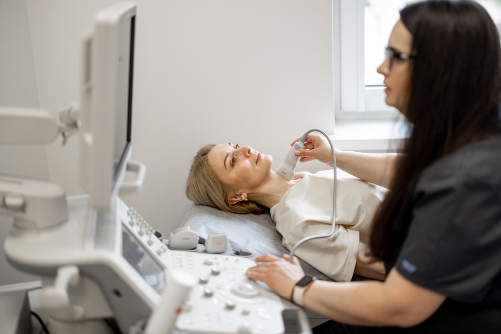 Ultrasound specialist examining thyroid of female patient. The concept of ultrasound diagnostics and women's health