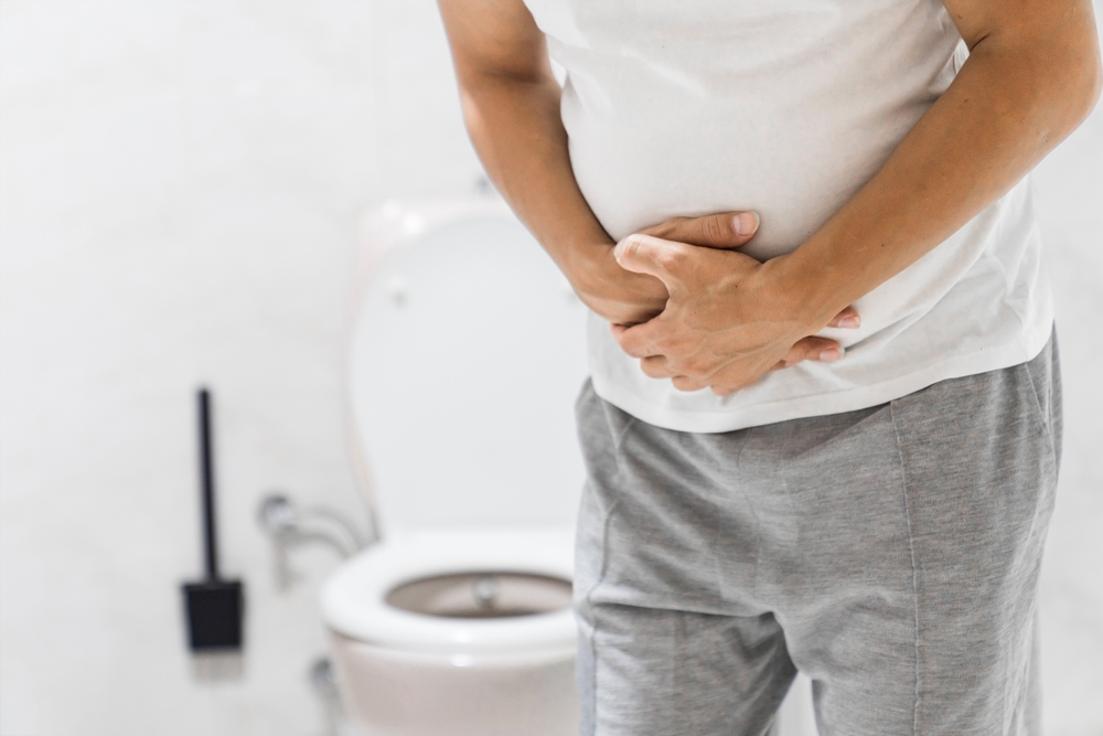 Men have stomachache and use their hands to hold their stomach In the bathroom. Constipation or colon cancer. diarrhea and severely toxic food. Man touch belly in the bathroom. Abdominal pain