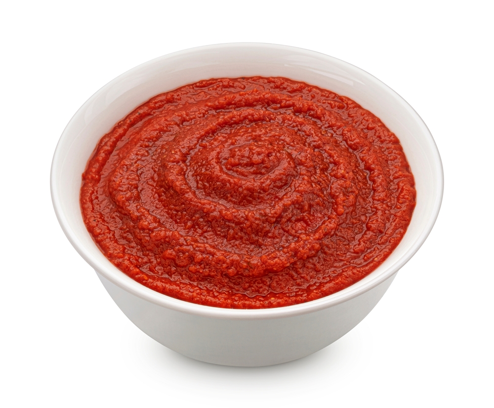 Tomato paste in bowl isolated on white background
